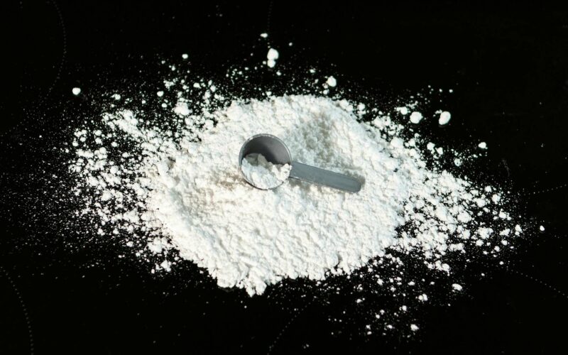 creatine hydrochloride powder on black background