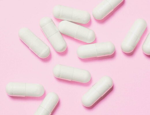 white vitamins for hearing on pink background